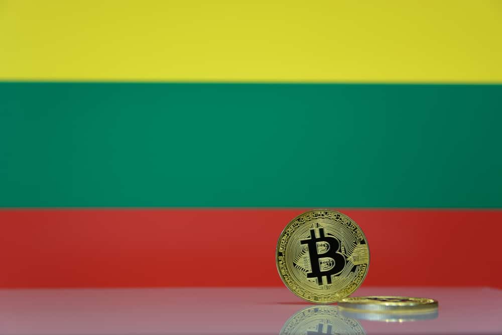 Golden bitcoin stands on a blurred background of state flag of Lithuania. Source: Shutterstock.com