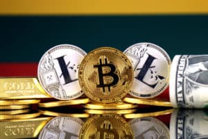 Physical version of Bitcoin, Litecoin, gold, US Dollar and Lithuania Flag. Conceptual image for investors in cryptocurrency, gold and dollars. Source: shutterstock.com