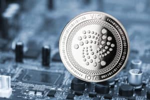 iota silver coin on blue motherboard chip digital mining computer hardware crypto currency financial background concept
