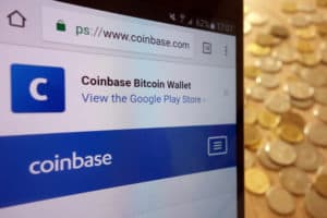 KONSKIE, POLAND - MAY 08, 2018: Coinbase cryptocurrency exchange website displayed on smartphone and stack of coins. Source: shutterstock.com