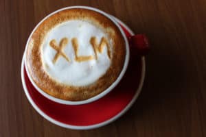 Coffee Cappuccino in a red cup with a symbol of Stellar Lumens XLM on milk foam. Source: shutterstock.com