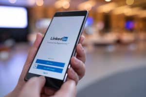 CHIANG MAI, THAILAND - August 03,2018: Woman hands holding HUAWEI mobile phone with Linkedin application on the screen. Linkedin is a business and employment oriented social networking service. Source: shutterstock.com