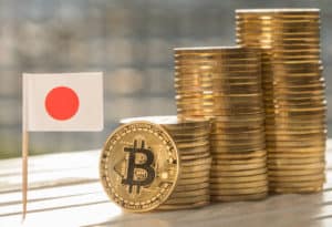 Bitcoin replica with mini Japan flag on table top. Source: shutterstock.com