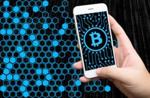 Distributed ledger technology , Man holding mobile phone, block chain text and blockchain icons with binary coded background , cryptocurrencies or bitcoin concept. Source: shutterstock.com