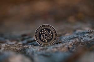 Iota cryptocurrency physical coin placed on the stone at the golden hour