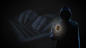 Golden Bitcoin floating above of hacker's hand in dark on hacker hacking with computer laptop background with copy space. Finance, business, e-commerce or cyber crime concept - Image