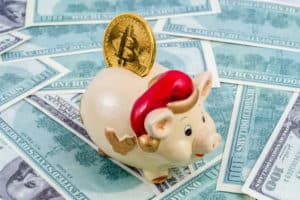 Piggy with santa hat on dollar bills background and bitcoin in it. Concept of saving bitcoin in 2019. piggy as symbol of upcoming new year. - Image