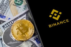 Apple iPhone and Binance logo and bitcoin, ethereum and dollars. Binance is a cryptocurrency exchange. Ekaterinburg, Russia - April 11, 2018 - Image