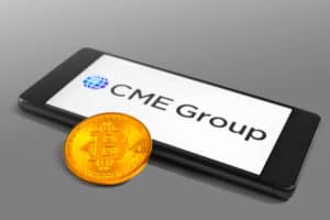 SLOVENIA - DECEMBER 16, 2018 CME Group logo on a mobile device with Bitcoin coin - Image